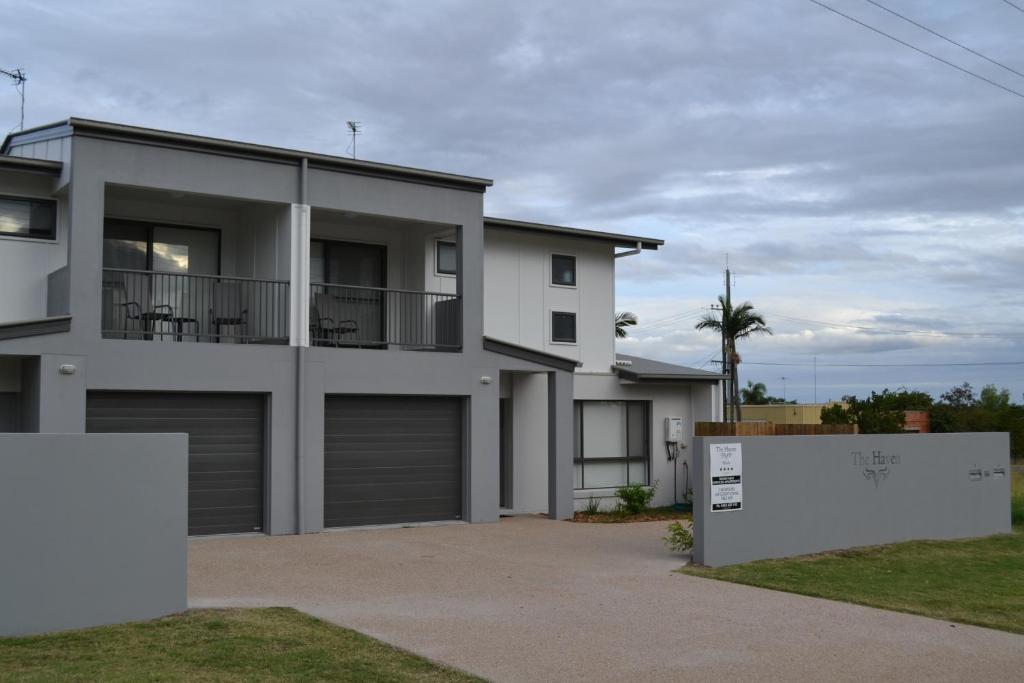 Street front of The Haven, two-storey grey townhouses with garages and The Haven sign on the front wall