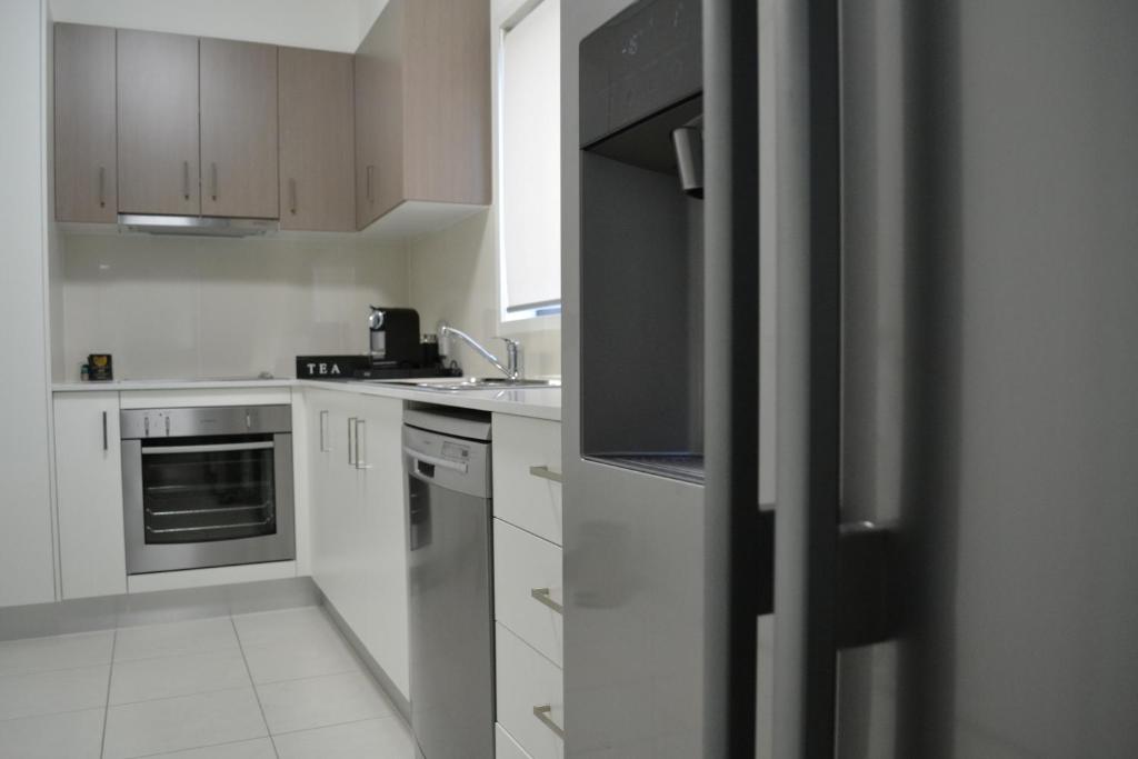 Kitchen with stainless steel oven, dishwasher and fridge