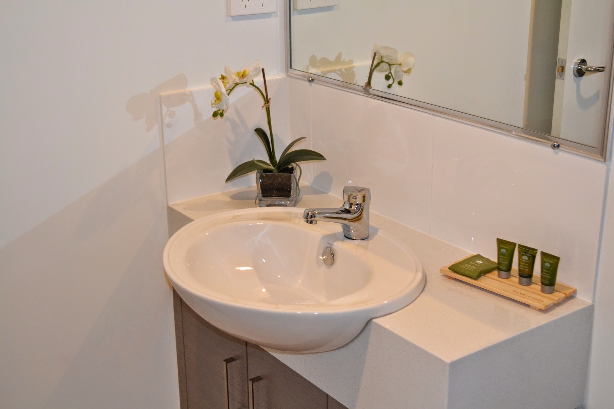 Bathroom vanity with an orchid and complimentary toiletries